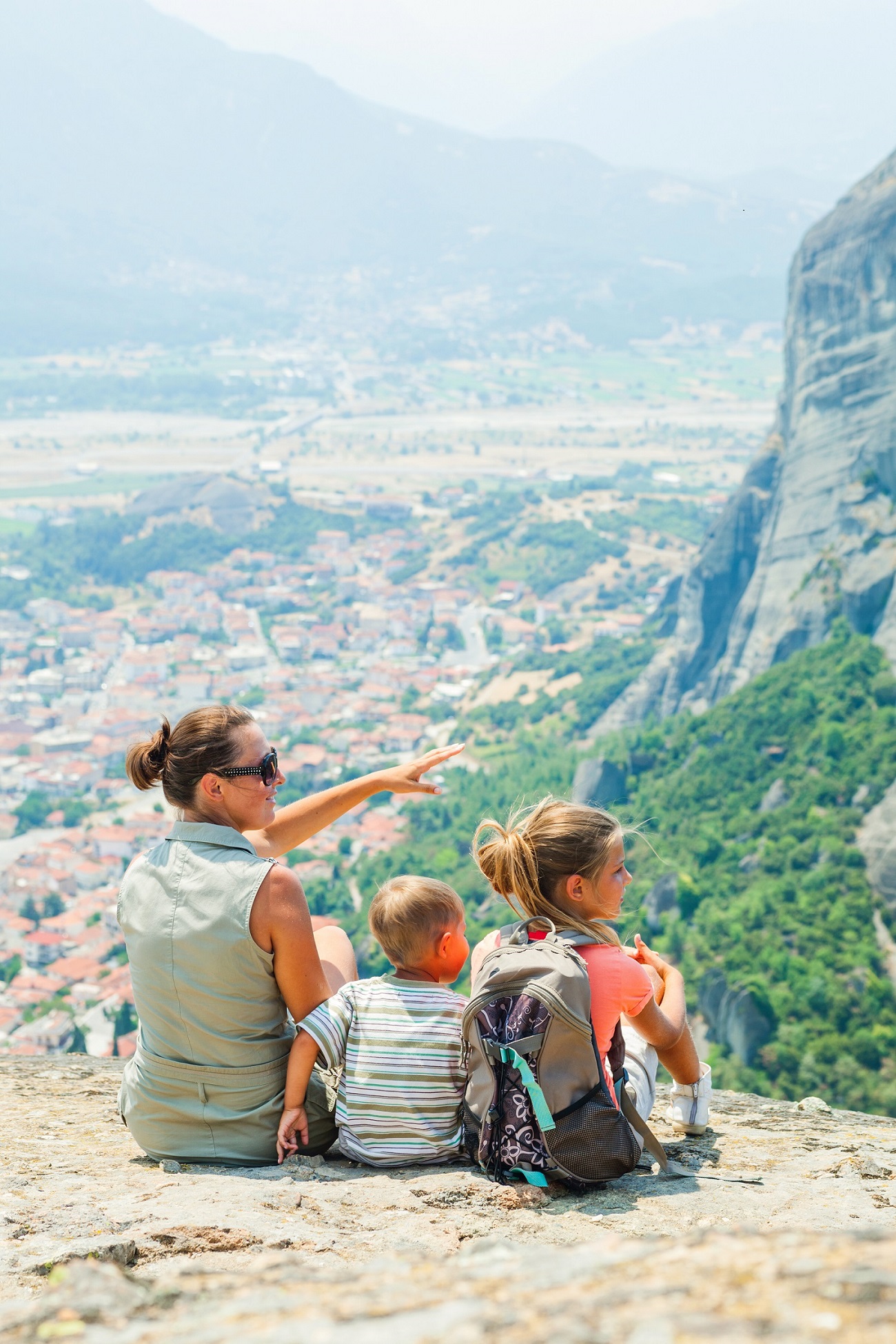 mother-and-her-kids-looking-at-the-town-of-kalambaka-bird-s-eye-view-vertical-view-meteora-greece.jpg