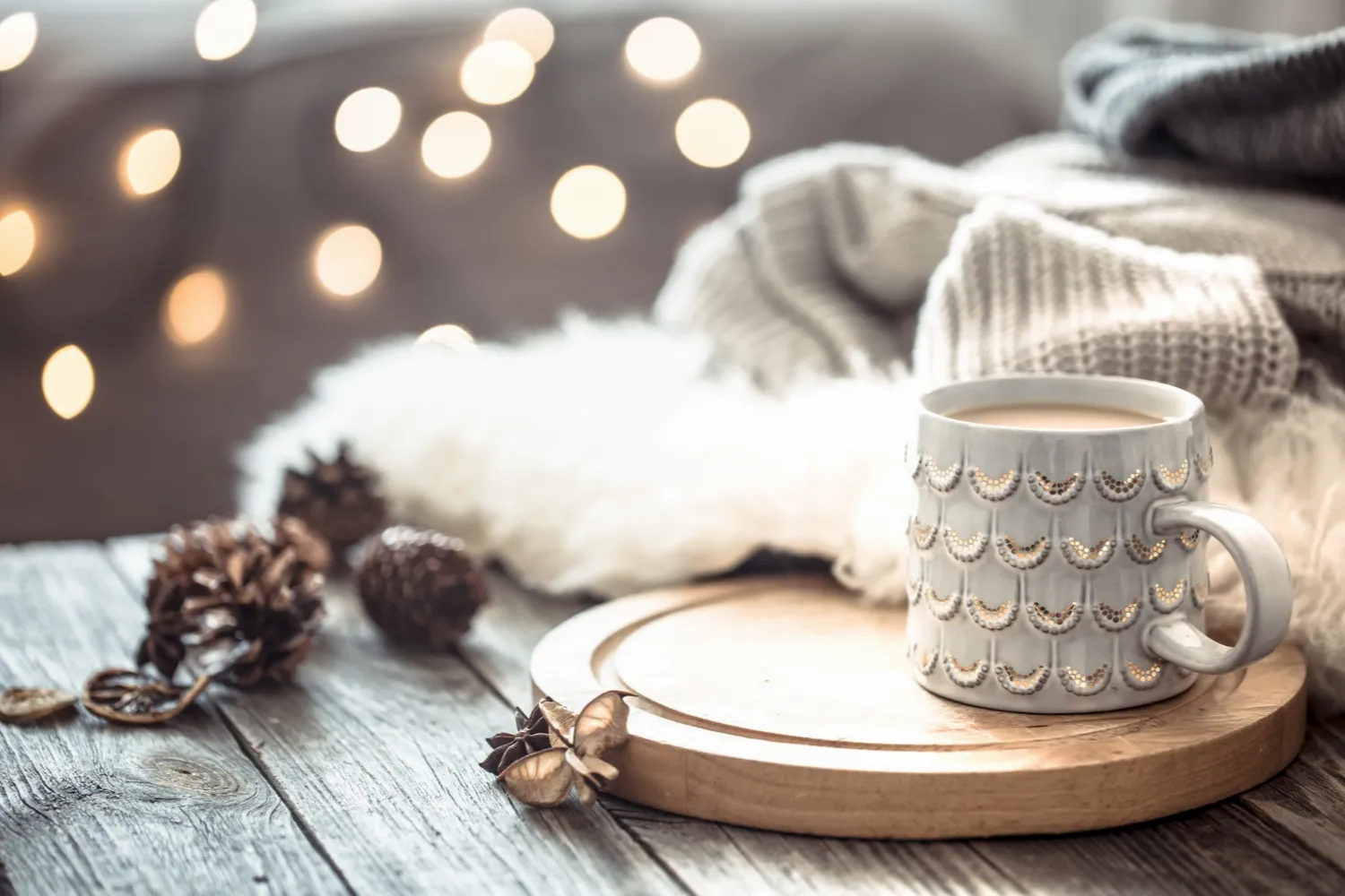 coffee-cup-christmas-lights-bokeh-home-wooden-table-with-sweater-wall-decorations-holiday-decoration