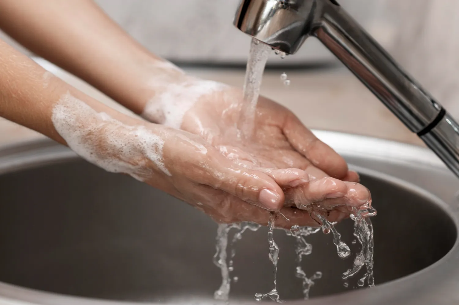person-washing-hands-sink-close-up