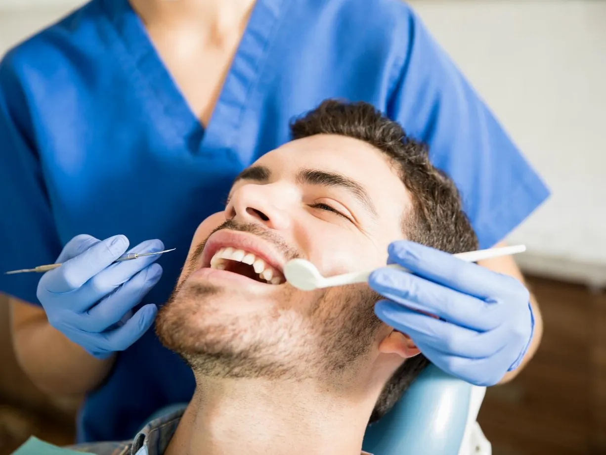 mid-adult-patient-receiving-dental-treatment-with-tools-from-female-dentist-clinic_662251-2562