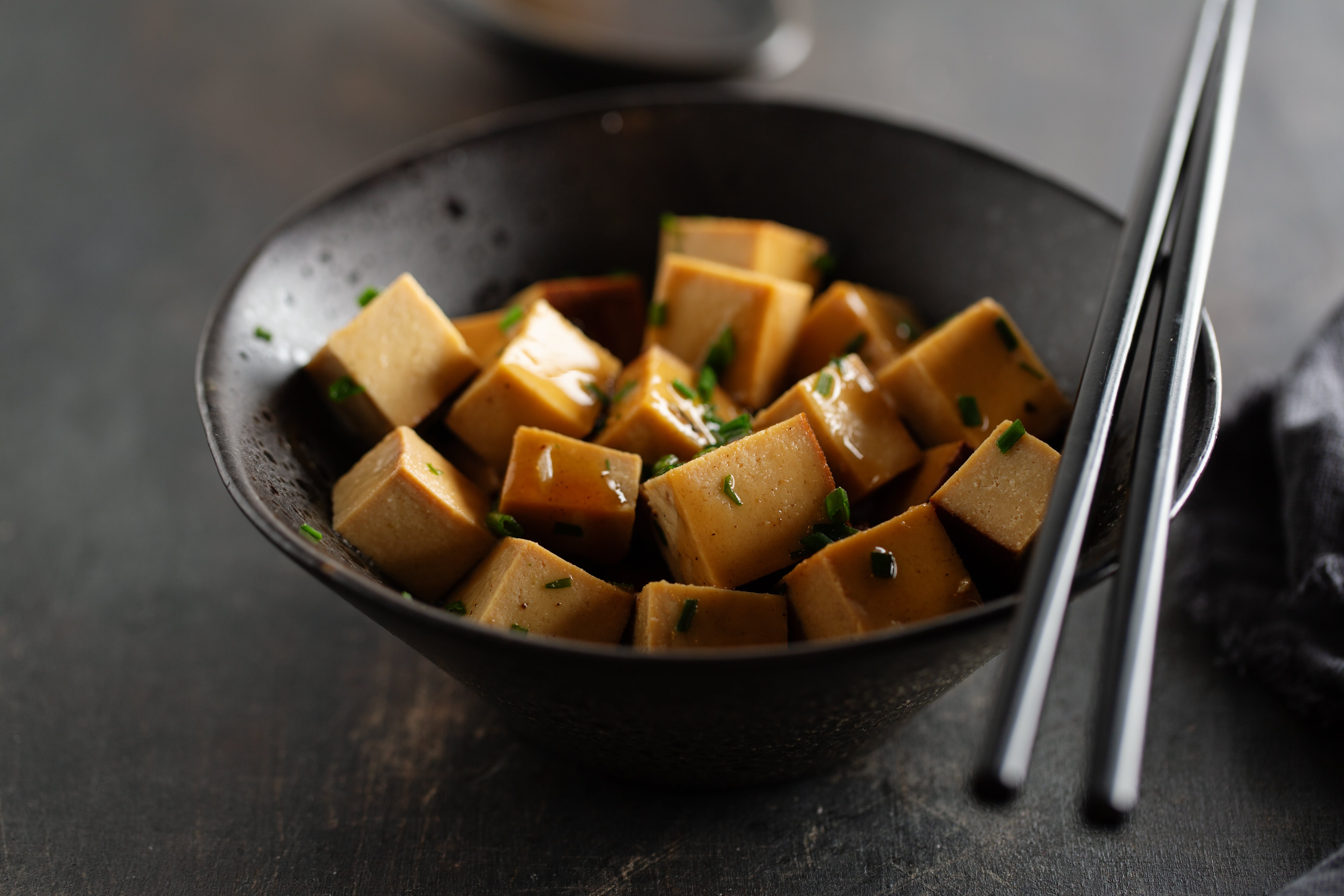tasty-appetizing-chunks-tofu-with-sauce-served-bowl-ready-eating-closeup-min.jpg